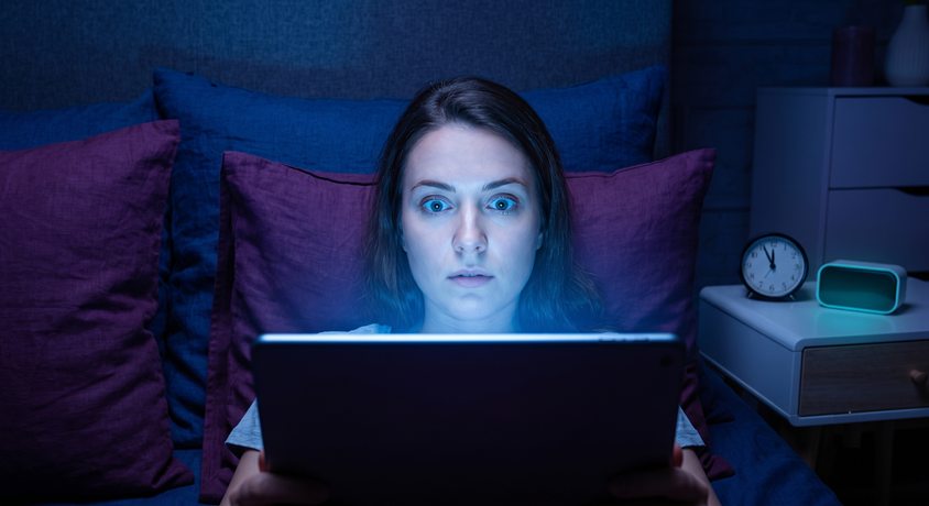 Illustration of a teenager using a tablet in bed during the evening